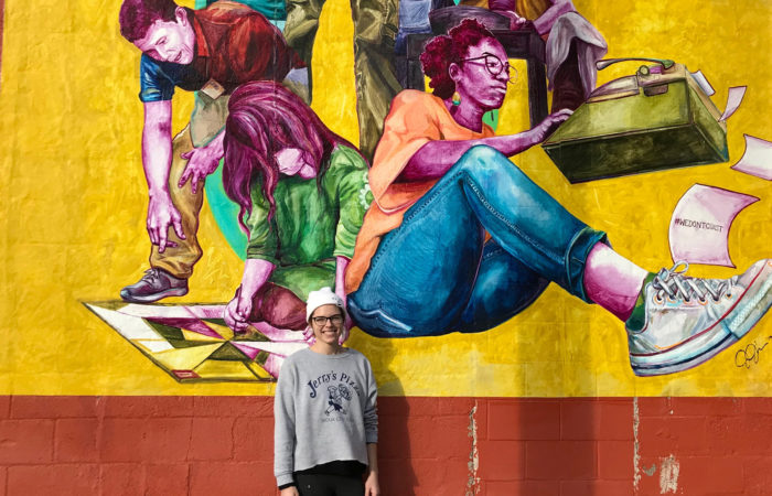 Artist Jenna Johnson next to mural